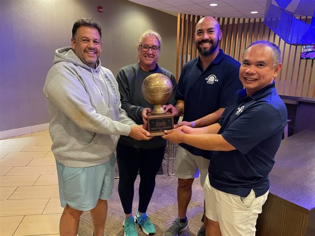 Coaches holding the bronze ball trophy